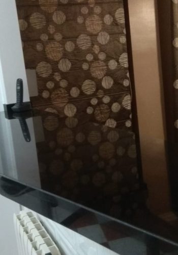 Cocina en blanco brillo, con encimera en granito negro y barra comunicada con el salón 1 (1)