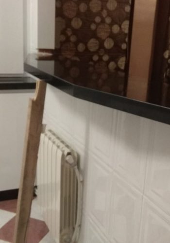 Cocina en blanco brillo, con encimera en granito negro y barra comunicada con el salón 1 (15)