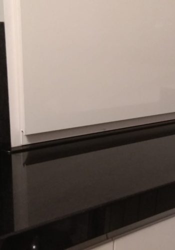 Cocina en blanco brillo, con encimera en granito negro y barra comunicada con el salón 1 (16)