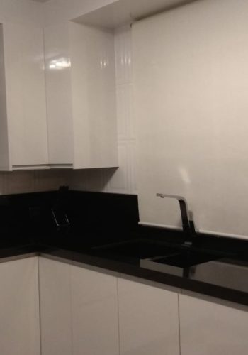 Cocina en blanco brillo, con encimera en granito negro y barra comunicada con el salón 1 (25)