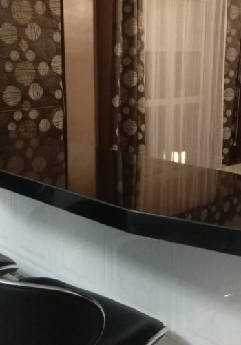 Cocina en blanco brillo, con encimera en granito negro y barra comunicada con el salón 1 (27)