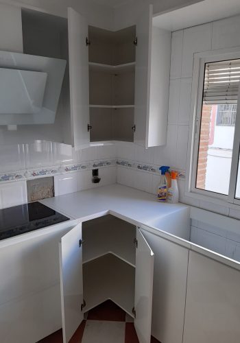 Cocina en blanco brillo, con encimera en granito negro y barra comunicada con el salón 1 (8)