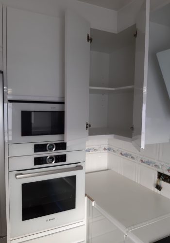 Cocina en blanco brillo, con encimera en granito negro y barra comunicada con el salón 1 (9)